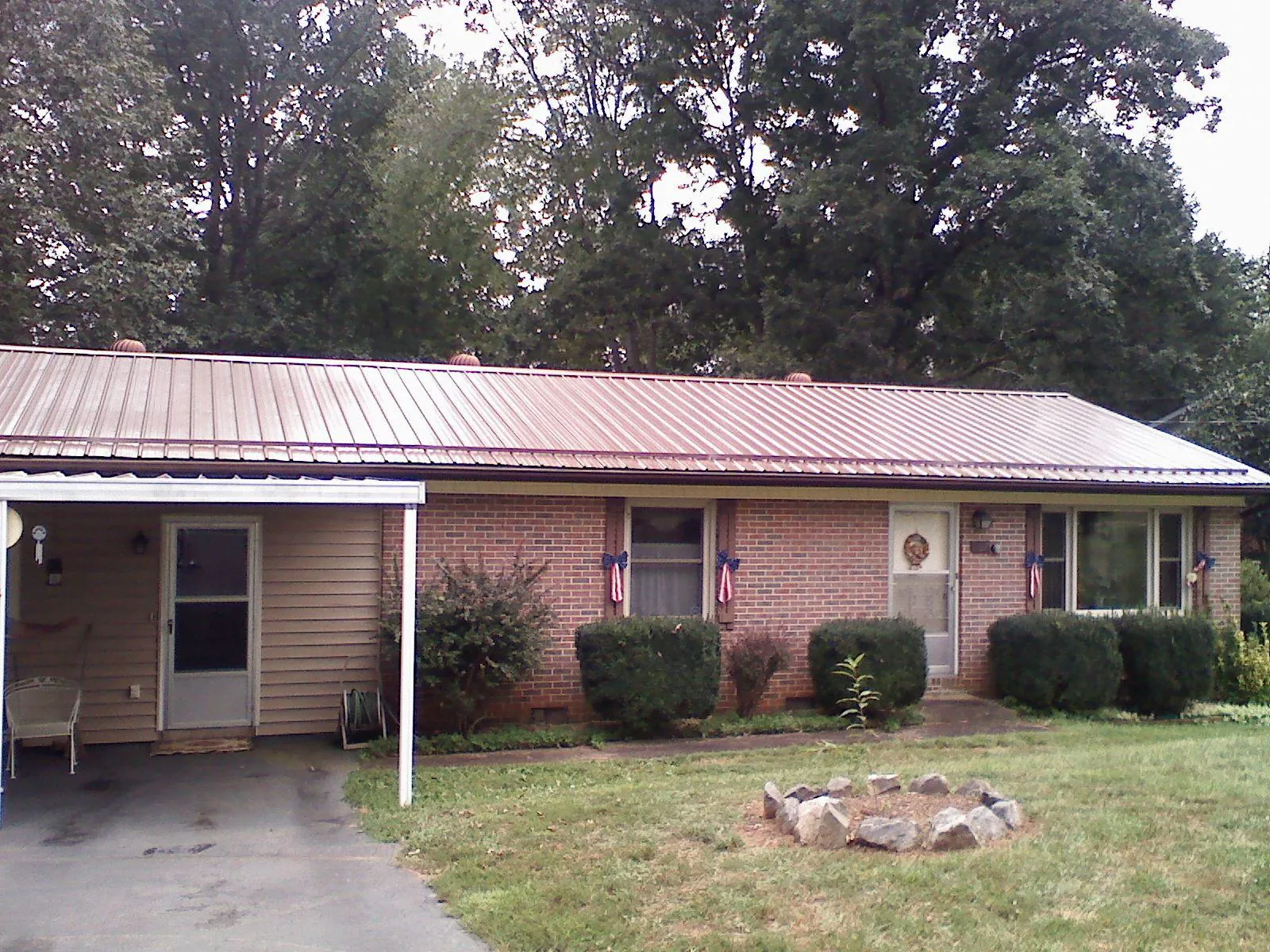 Bronze metal roof and carport on a brick ranch home — Roof Repair work by our crew in Moulton